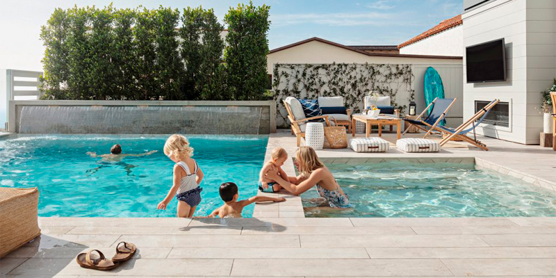 Familia en el interior de una piscina y un spa, con fonfo móvil Akvo Spiralift