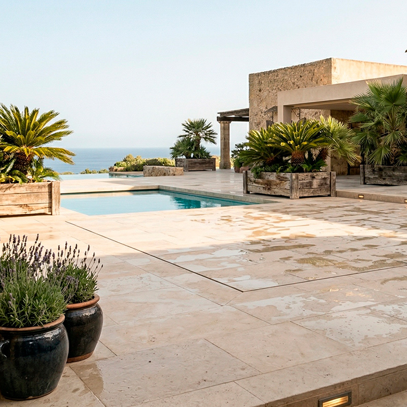 Plataforma móvil transitable de piedra caliza unificada ocultando la piscina en villa con palmeras.