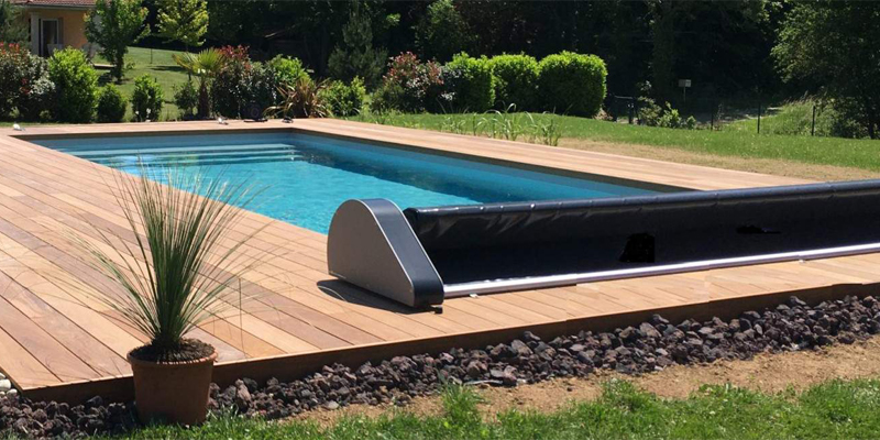 Cubierta de piscina Oré en un jardín con tarima de madera